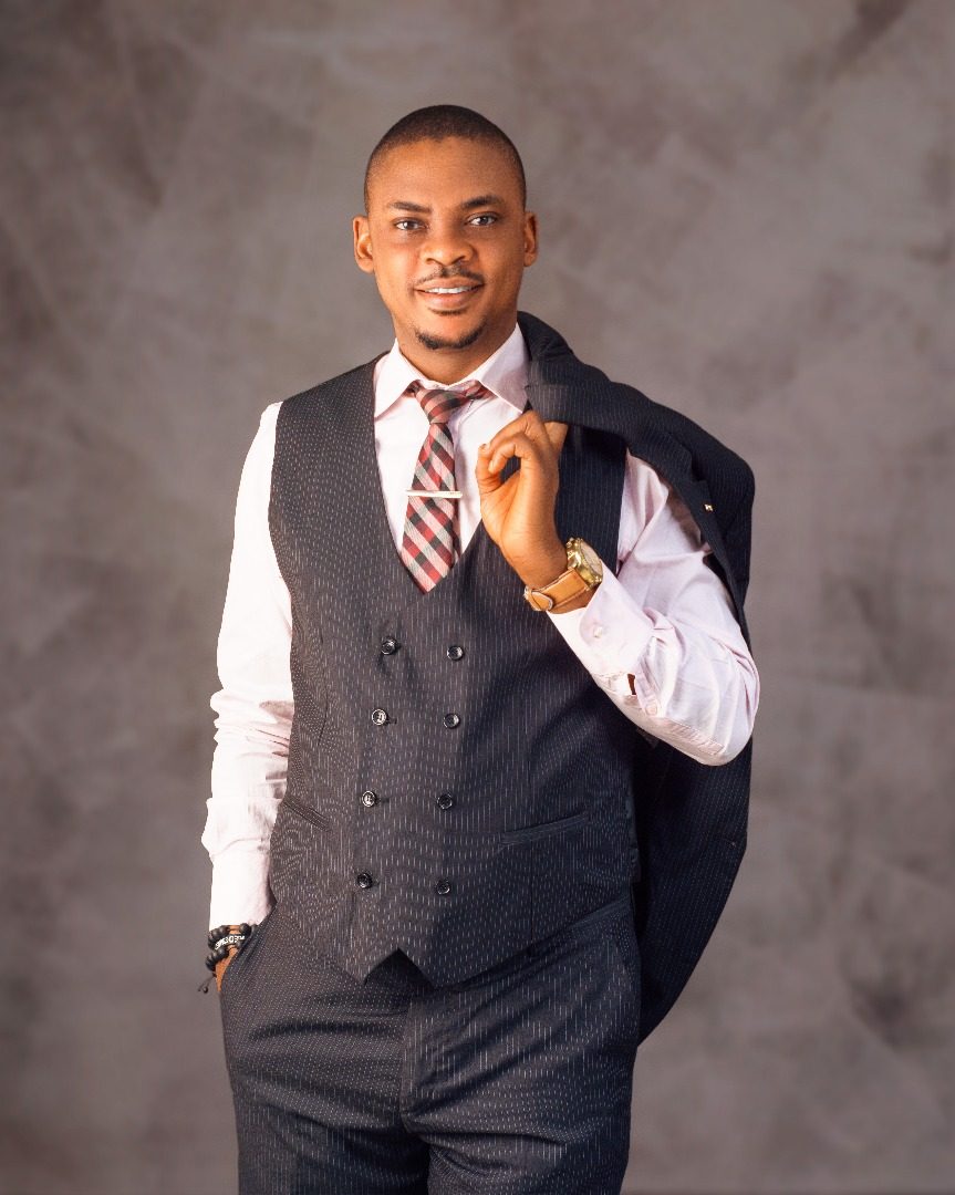 Dr. Babatunde Amao in a pinstripe waistcoat with his jacket over his shoulder